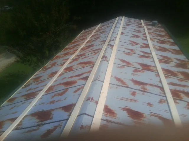 Rusted metal roof panels with new wood purlins before replacement — Storm Damage Roof Repair in Holly Bluff by Roofing Brothers